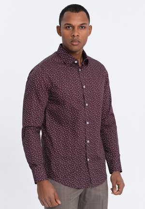 Chemise pour homme couleur bordeaux avec un motif floral blanc, design à boutons, manches longues et col classique. Texture de tissu lisse.
