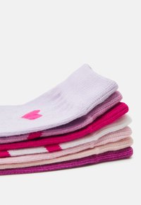 Fem par sokker i forskellige nuancer af lilla og pink, med en blanding af ensfarvede og mønstrede designs, lavet af blødt, tekstureret stof.