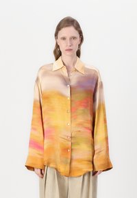 Satin shirt featuring a gradient pattern in orange, pink, and yellow hues, with a collared neckline and button-down front.