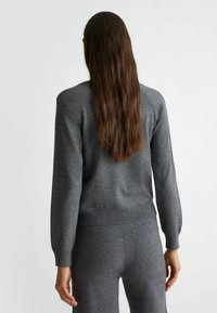 Maglione grigio lavorato a maglia con polsini e orlo a coste, caratterizzato da un collo rotondo e maniche raglan, progettato per una vestibilità comoda.