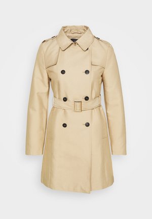Beige dobbeltradet trenchcoat med sorte knapper, bælte med rektangulær spænde, skulderklapper og lange ærmer.