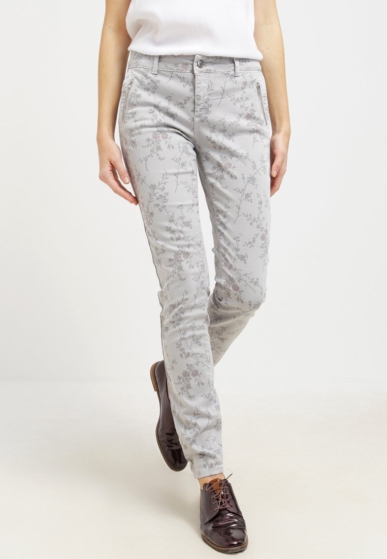 Ljusgrå byxor med ett blommönster, som har en slim fit, bälteshällor och framfickor. I kombination med mörkbruna skor.