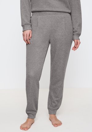 Grå sweatpants i mjukt tyg, med elastisk midja, sidofickor och ribbade muddar, som smalnar av mot anklarna.