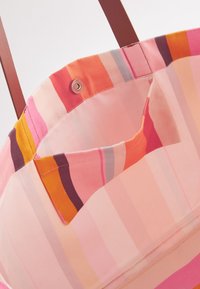 Geantă tote cu dungi multicolore în nuanțe de roz, portocaliu și mov. Interiorul are un buzunar mic și un sistem de închidere cu capsa pentru depozitare sigură.