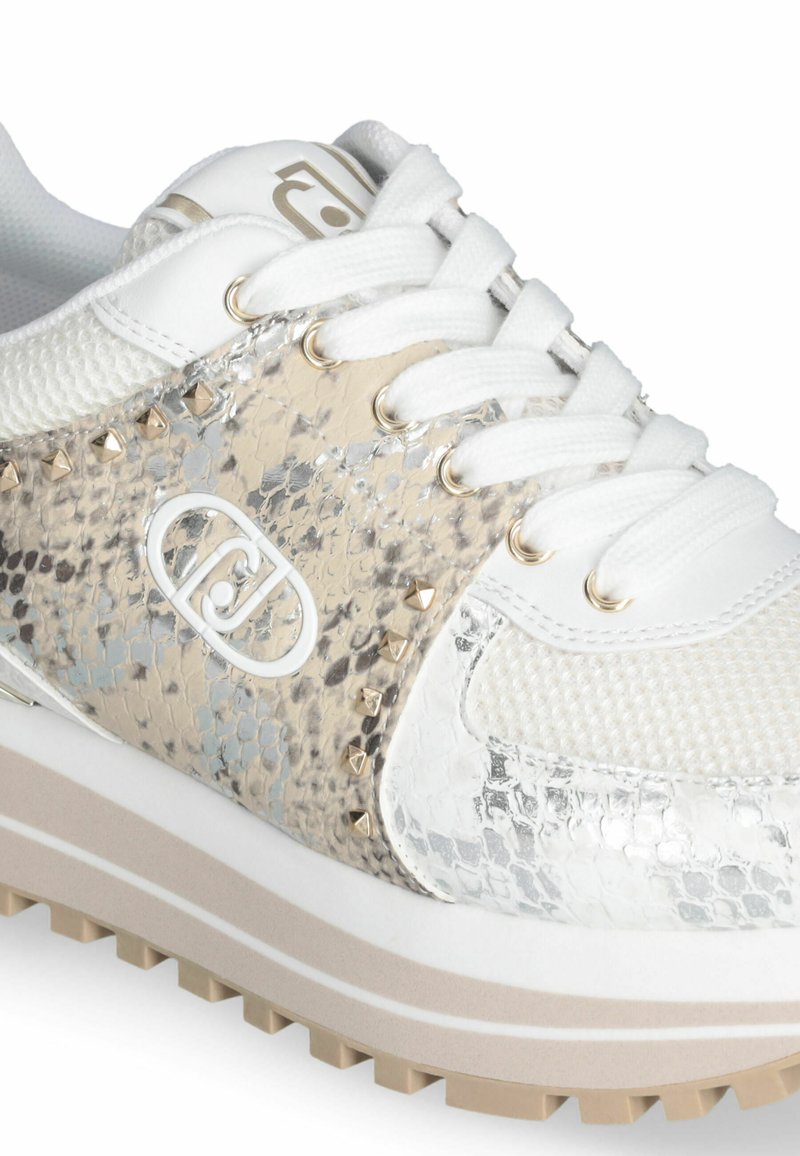 Biała sneakersy z teksturowanej siateczki i metalicznymi akcentami w reptilowym wzorze. Posiadają srebrne elementy hardware oraz wystające detale po bokach.