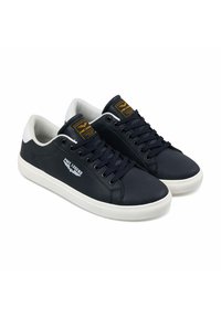 Marineblauwe sneakers met een glad synthetisch bovenwerk, witte accenten op de hiel en een beige rubberen zool. Voorzien van platte veters en een logo patch.