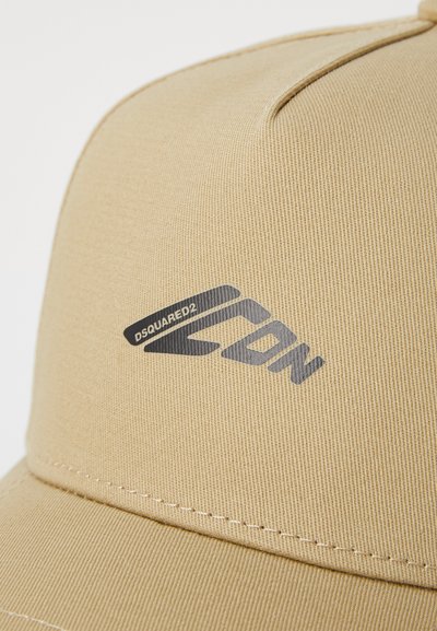 Casquette beige en tissu texturé avec un logo noir en relief "DSQUARED2 ICON" sur le devant, avec des coutures contrastantes le long de la visière.