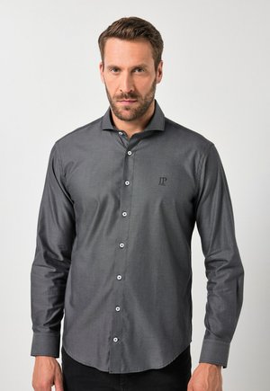 Camisa gris de botones con una textura sutil, mangas largas y botones blancos; presenta un pequeño logo bordado en el pecho.