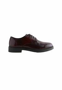 Weinrote Lederschuhe mit glänzender Oberfläche, runder Zehenpartie und schwarzer Schnürung. Dicke schwarze Außensohle und glatte Textur.