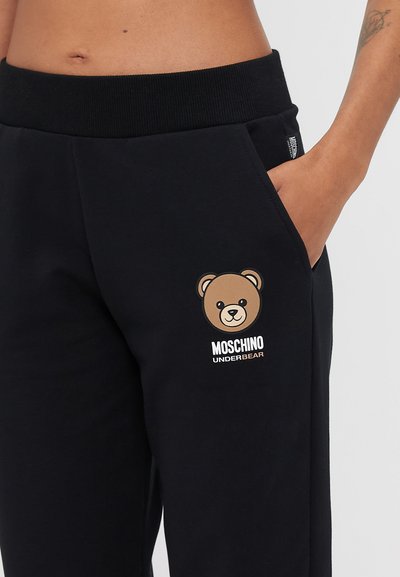 Melni sporta bikses ar gaiši brūnu lāča grafiku un tekstu "MOSCHINO UNDERBEAR" baltā krāsā. Mīksta auduma ar ribotu jostu.