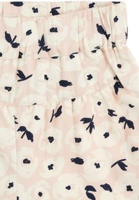 Tissu rose clair avec un motif floral blanc et des accents marins. Taille élastique, texture froncée et matériau doux.
