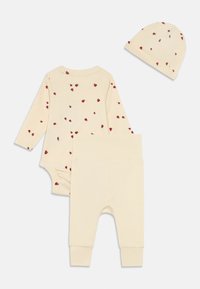 Set za dojenčke v kremni barvi, ki vključuje bodi z dolgimi rokavi in klobuček s tiskanimi pikapolonicaste vzorec rdeče barve, v kombinaciji z enotnimi kremnimi hlačami.