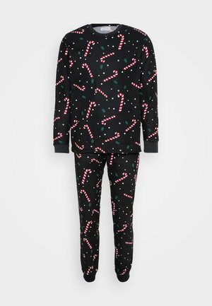Schwarzes Schlafanzugset aus weichem Stoff, bestehend aus einem Langarmshirt und einer Hose, dekoriert mit Zuckerstangen- und Schneeflockenmuster in Rot und Weiß.