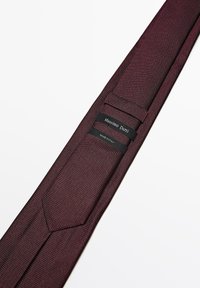 Bordeaux tekstureret slips med et subtilt mønster, der har to sorte etiketter: den ene med "Massimo Dutti" og den anden med "MADE IN ITALY."