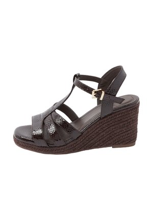 Donkerbruine sleehak sandaal met gevlochten touwzool, glanzende textuurbandjes en goudkleurige gesp bij de enkel.
