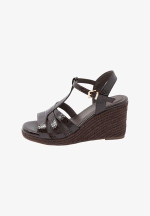 Dunkelbraune Keilsandalette mit geflochtener Seilsohle, glänzenden, strukturierten Riemen und goldfarbener Schnallenverschluss am Knöchel.