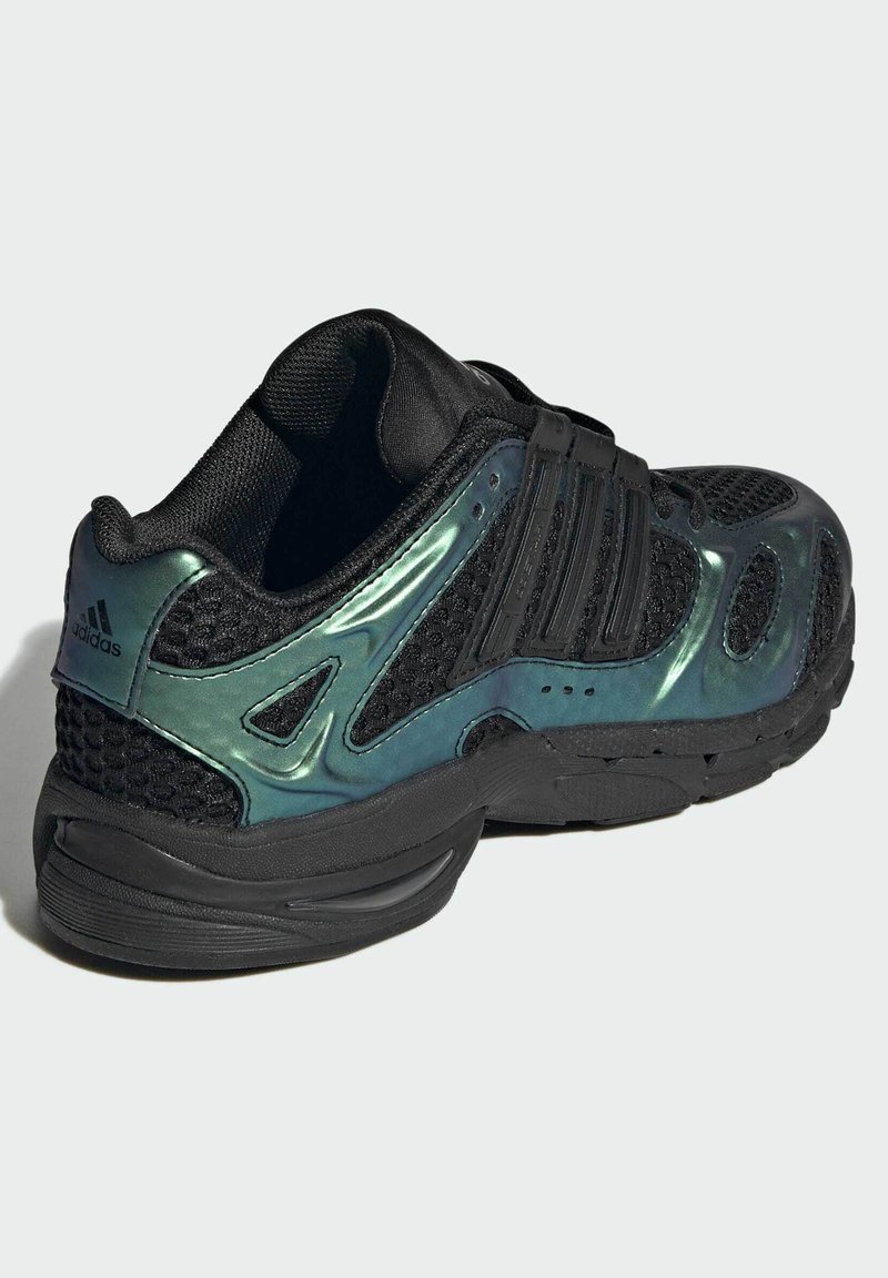 Sort Adidas sportsko med iriserende grønne sidepaneler, mesh-overdel og tre velcrobånd til lukning, vist fra bagfra i sidevinkel.