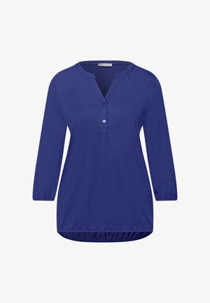 Damska niebieska bluzka z długim rękawem, dekoltem w serek zapinanym na trzy guziki oraz marszczonym, elastycznym dołem i mankietami, gładka tkanina, styl casual.