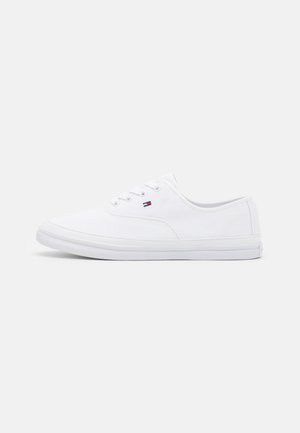 Niski biały sneaker z białymi sznurowadłami i małym czerwono-biało-niebieskim logo z boku, na jednolitym tle.