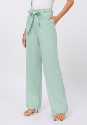 Pantaloni a gamba larga verde menta con cintura in tessuto, tasche laterali e una texture liscia e leggera. Vita aderente con una vestibilità rilassata lungo le gambe.