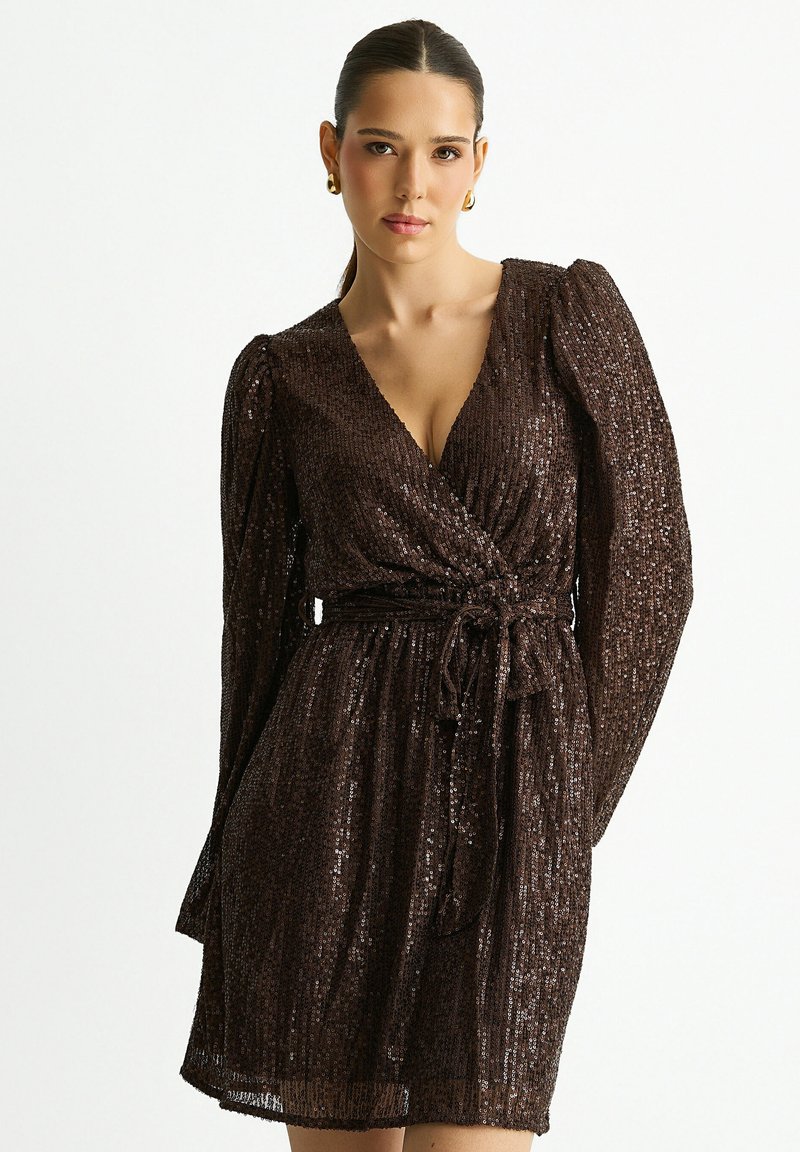 Brown sequin dress with a V-neck, long puff sleeves, and a waist tie. Designed with a textured surface and a short length.
