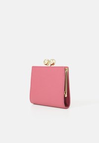 Portafoglio in pelle rosa con una texture liscia, dotato di una chiusura e una cerniera in metallo dorato. Forma rettangolare compatta, design minimalista.