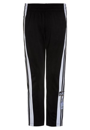 Pantalon de survêtement noir avec bandes blanches sur les côtés et taille élastique, avec écussons du logo Adidas sur la jambe droite près du genou.