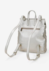 Mochila metálica plateada hecha de cuero texturizado. Cuenta con correas ajustables, asas superiores y un bolsillo frontal con cremallera.