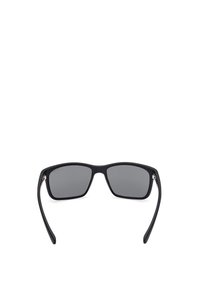 Gafas de sol negras con un acabado mate, lentes rectangulares y tinte gris oscuro. Presentan patillas delgadas y sutiles acentos metálicos.