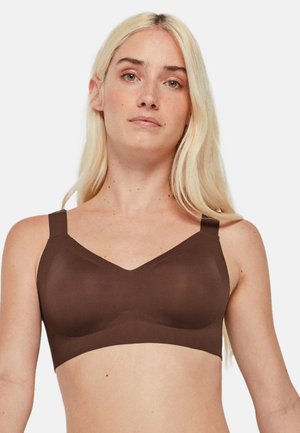 Sujetador inalámbrico marrón con un diseño suave y sin costuras, en forma de escote en V y con tirantes ajustables. Tejido suave y elástico para mayor comodidad.