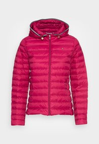 Väriltään kirkkaan pinkki toppatakki, jossa on vetoketjullinen etuosa, huppu ja vinokuvioinen tikkaus. Takissa kullanväriset yksityiskohdat ja kontrastivärinen reunus.