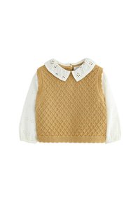 Gilet en tricot beige avec un motif en diamant, comprenant une blouse blanche en dessous avec des détails floraux brodés et un col rond.