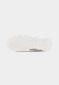 Λαστιχένια σόλα μπεζ αθλητικού παπουτσιού με μοτίβο πέλματος σε σχήμα διαμαντιού και μέγεθος 37 σημειωμένο στο κάτω μέρος, εμφανίζεται σε λευκό φόντο.