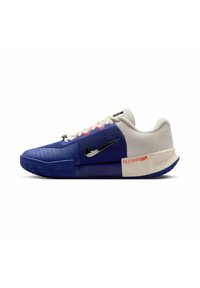 Scarpa da basket Nike, con una tomaia blu in tessuto testurizzato, dettagli in rete bianca e logo Swoosh nero. Presenti dettagli rossi e grigi.