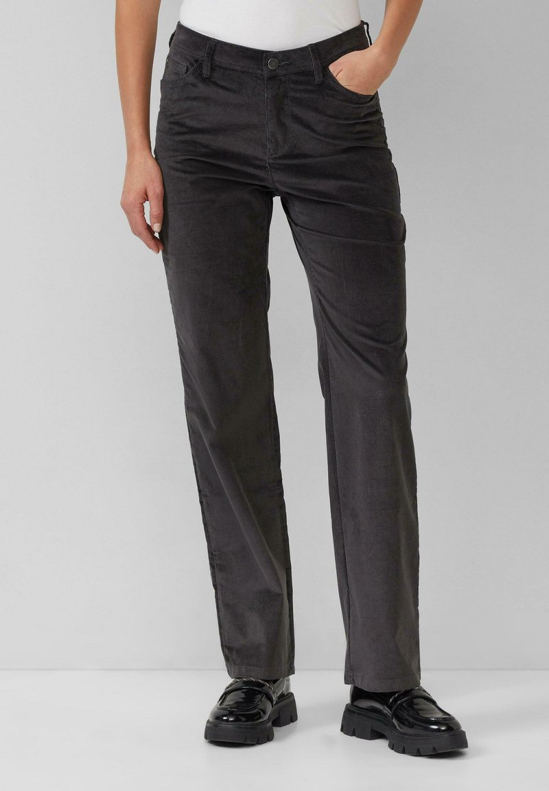 Pantalons en velours côtelé gris avec une coupe droite, dotés de poches avant, d'une fermeture à bouton et d'une texture douce. Accompagnés de mocassins noirs.