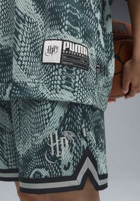 Basketball jersey and shorts set in textured green snake print, featuring a PUMA label, HP logo, and contrasting black trim with grey accents.