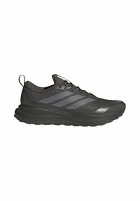 Baskets de sport noires avec des bandes grises, semelle épaisse et rembourrée, fermeture à lacets et languette au talon, vue de profil.
