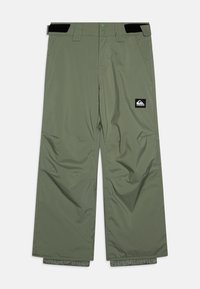 Vattentåliga snöbyxor i olivgrön, med lös passform, två framfickor och en logopatch. Elastiska muddar vid fållarna.