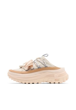 Baskets beige à enfiler avec semelle épaisse nervurée, lacets décoratifs et détail de nœud en tissu sur le côté supérieur.