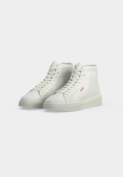 Paire de baskets montantes blanches avec lacets et logo rouge "HUGO" sur le côté, présentée sur un fond clair uni.