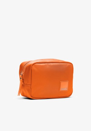 Trousse de toilette compacte rectangulaire orange avec fermeture éclair et petit patch logo SWIMS à l'avant, présentée sur fond blanc.