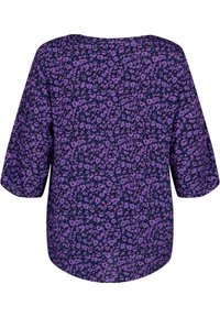 Blouse violet à imprimé léopard noir, avec une coupe ample et des manches larges. Texture lisse, encolure ronde et ourlet arrondi.