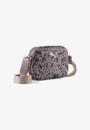 Petit sac bandoulière avec imprimé abstrait mauve et noir, logo Puma doré et bandoulière beige ajustable sur fond blanc.