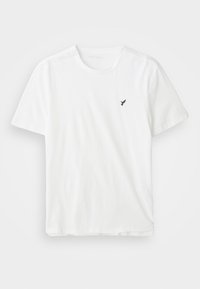 Λευκό βαμβακερό t-shirt με κοντά μανίκια, στρογγυλή λαιμόκοψη και ένα μικρό μαύρο λογότυπο πτηνού στην αριστερή πλευρά του στήθους. Απλός και αδαής σχεδι�ασμός.