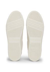Hvite sneakersåler med en teksturert, sklisikker overflate. Funksjoner inkluderer horisontale og vertikale spor med et logoavtrykk.