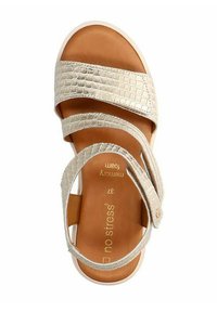 Beige sandal with a crocodile texture, dual straps, and a memory foam insole. Features a smooth, light-colored sole and logo detail.