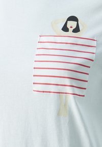 Illustration av en kvinna med svart hår och röda läppar, med armarna bakom huvudet, en ficka sydd av randig handduk som täcker hennes kropp på vit tyg.