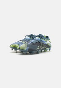 Scarpe da calcio con un design multicolore, con accenti blu, verdi e gialli. Realizzate in materiale sintetico con tacchetti sagomati per una migliore trazione.