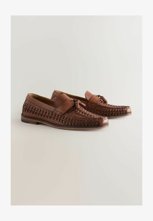 Mocasines de cuero marrón con diseño trenzado, suela plana y un nudo decorativo en la cinta. Textura suave con un acabado pulido.