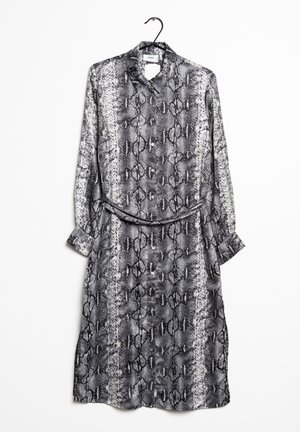 Robe à imprimé serpent noir et blanc avec manches longues, fermeture à boutons, col montant et une ceinture assortie. Tissu lisse et léger.